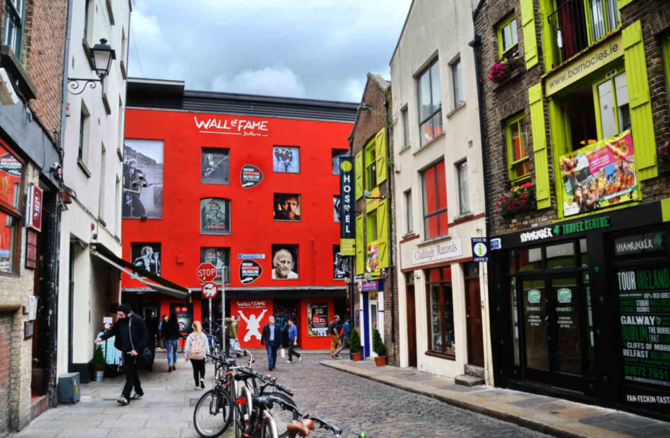 Dublin's colorful Irish Rock ‘n Roll Museum exterior with a "Wall of Fame" featuring famous musicians, and pedestrians walking by.