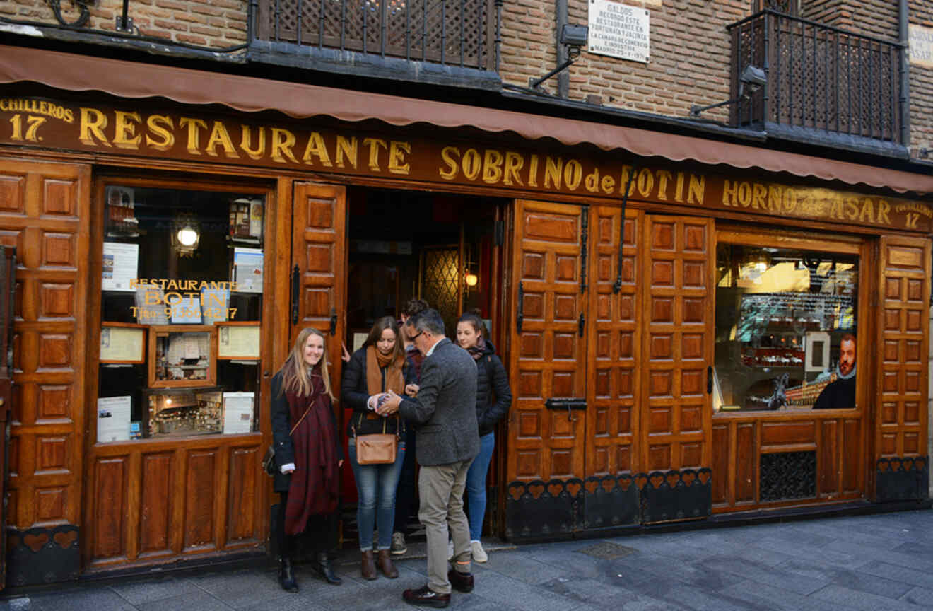 The entrance of Restaurante Botin in Madrid, recognized as the world's oldest restaurant, with patrons and wooden vintage décor