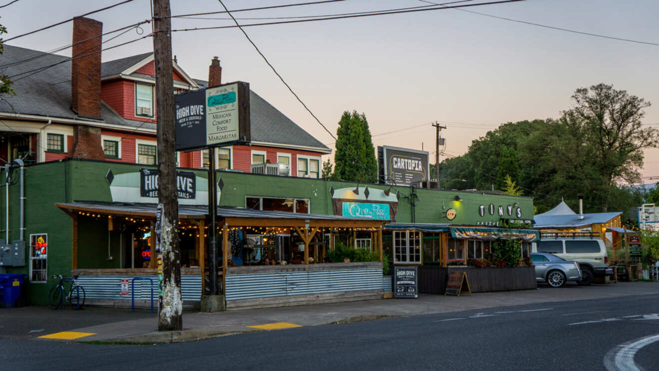 Evening view of a popular street corner in Central Eastside Portland featuring eclectic dining spots like Cartopia