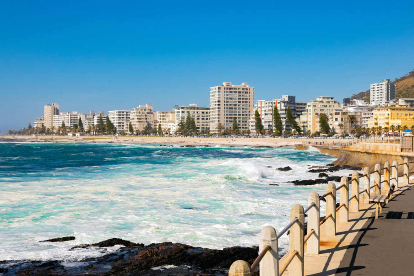 Seaside promenade in Sea Point, Cape Town, with its calm ocean waters, beachfront, and modern apartment buildings against a clear blue sky