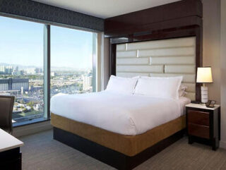 Modern hotel room with a large bed and a floor-to-ceiling window