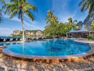 Circular resort pool with palm trees and ocean view in the backdrop in Krabi