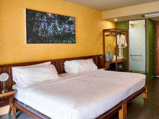 Minimalistic hotel room with a large bed and tropical forest picture in Krabi, Thailand
