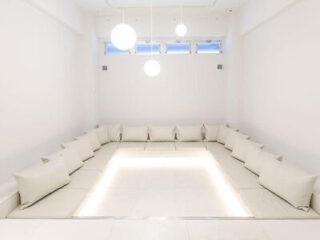 A minimalist white seating area with built-in benches and soft cushions