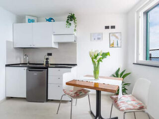 Bright kitchenette with modern appliances and a small dining table with two chairs
