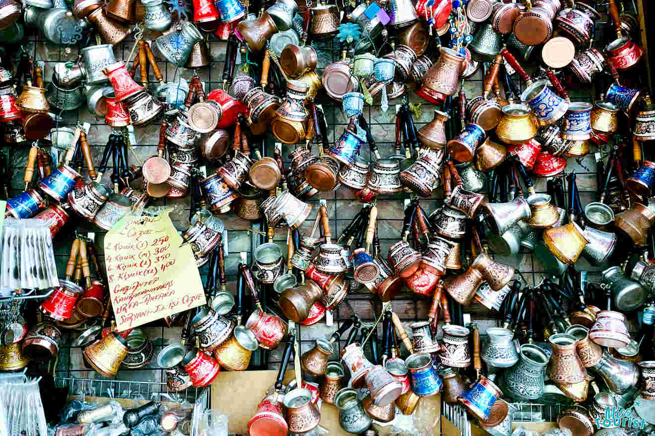 Wall display of various metal turkish coffee pots and a sign with prices