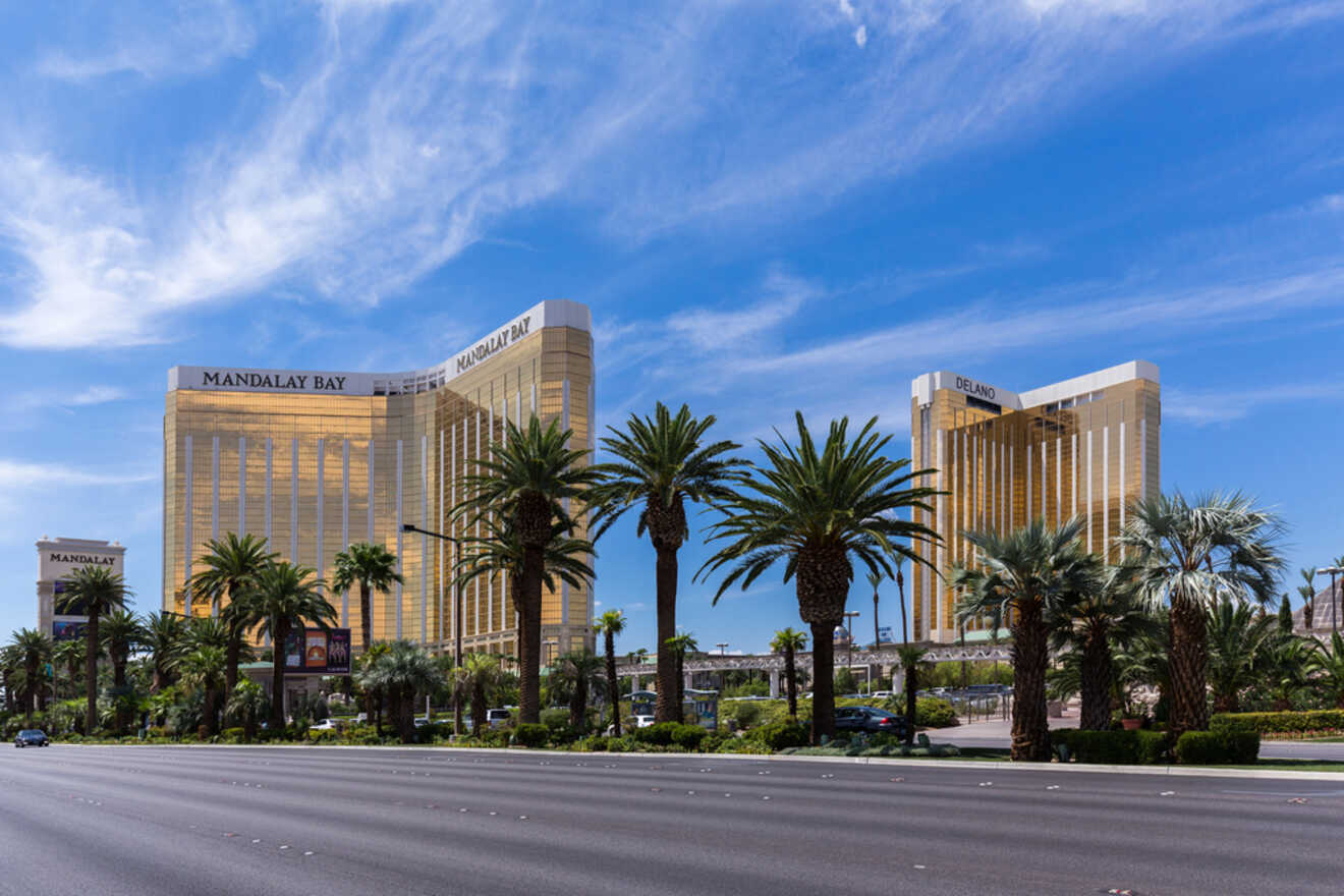 Golden facade of Mandalay Bay Resort and Casino towering over palm trees under a blue sky on the Las Vegas Strip
