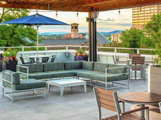 Outdoor lounge terrace with cushioned sofas and views of Portland's skyline