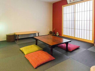 A traditional Japanese sitting room with tatami mats, a low wooden table, and floor cushions