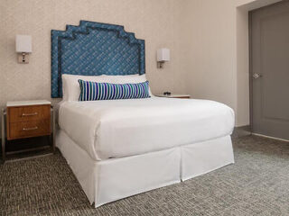 Chic bedroom at with a blue patterned headboard and bedside lamps
