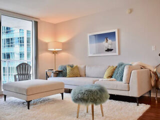 Cozy living room with plush sofa, soft-textured ottoman, and tasteful artwork
