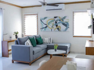 A chic living room in a modern apartment with a large gray sectional sofa and abstract wall art.