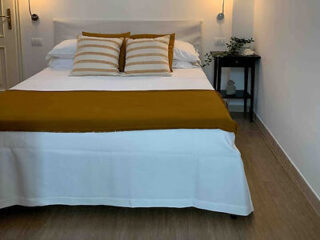 Stylish modern bedroom with a large bed featuring a white and mustard duvet