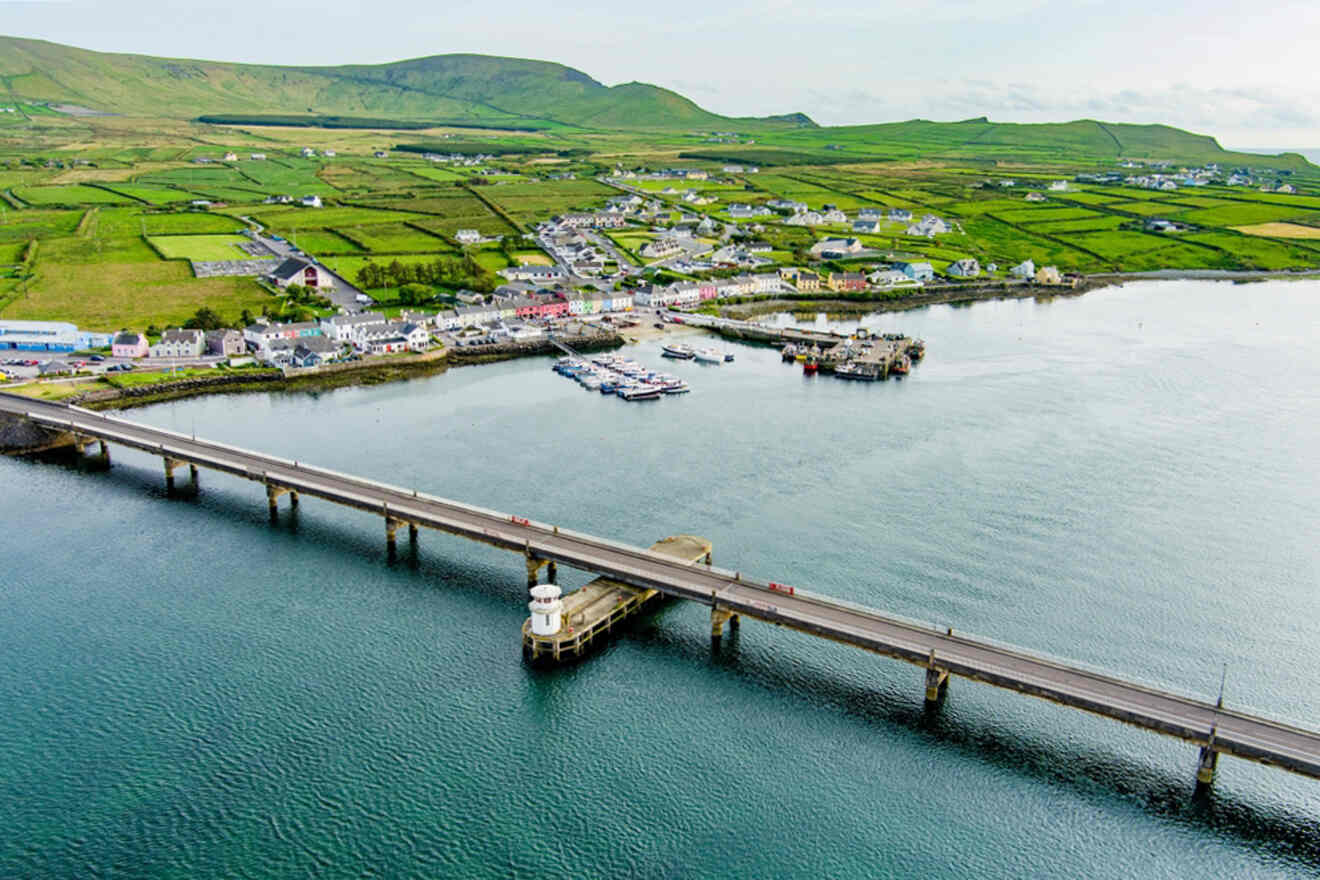 An aerial view of a long bridge connecting a vibrant coastal village to the mainland, illustrating the connectivity and charm of Ireland's coastal communities
