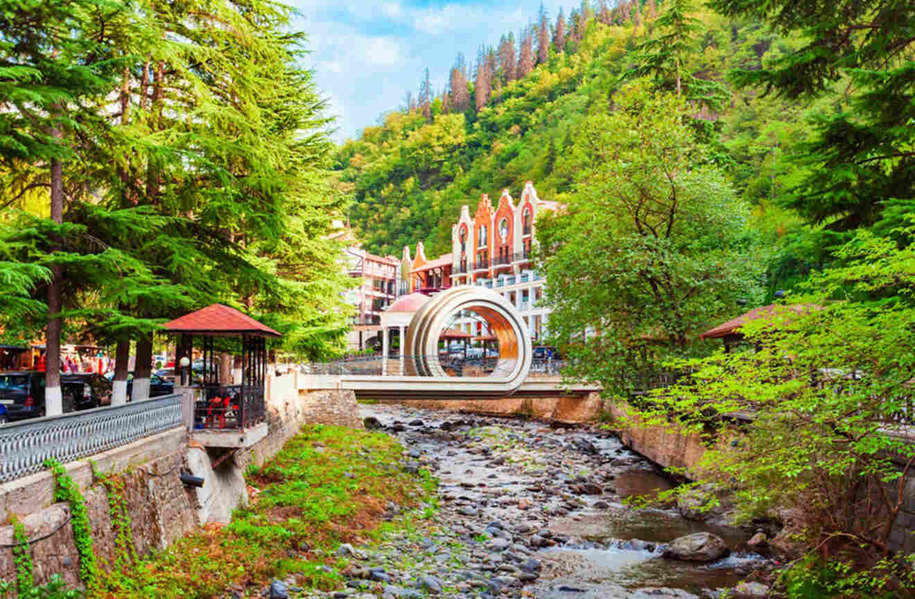 A lush scene in Borjomi with dense trees flanking a peaceful river, with architectural elements blending into the vibrant landscape, showcasing nature's tranquility.