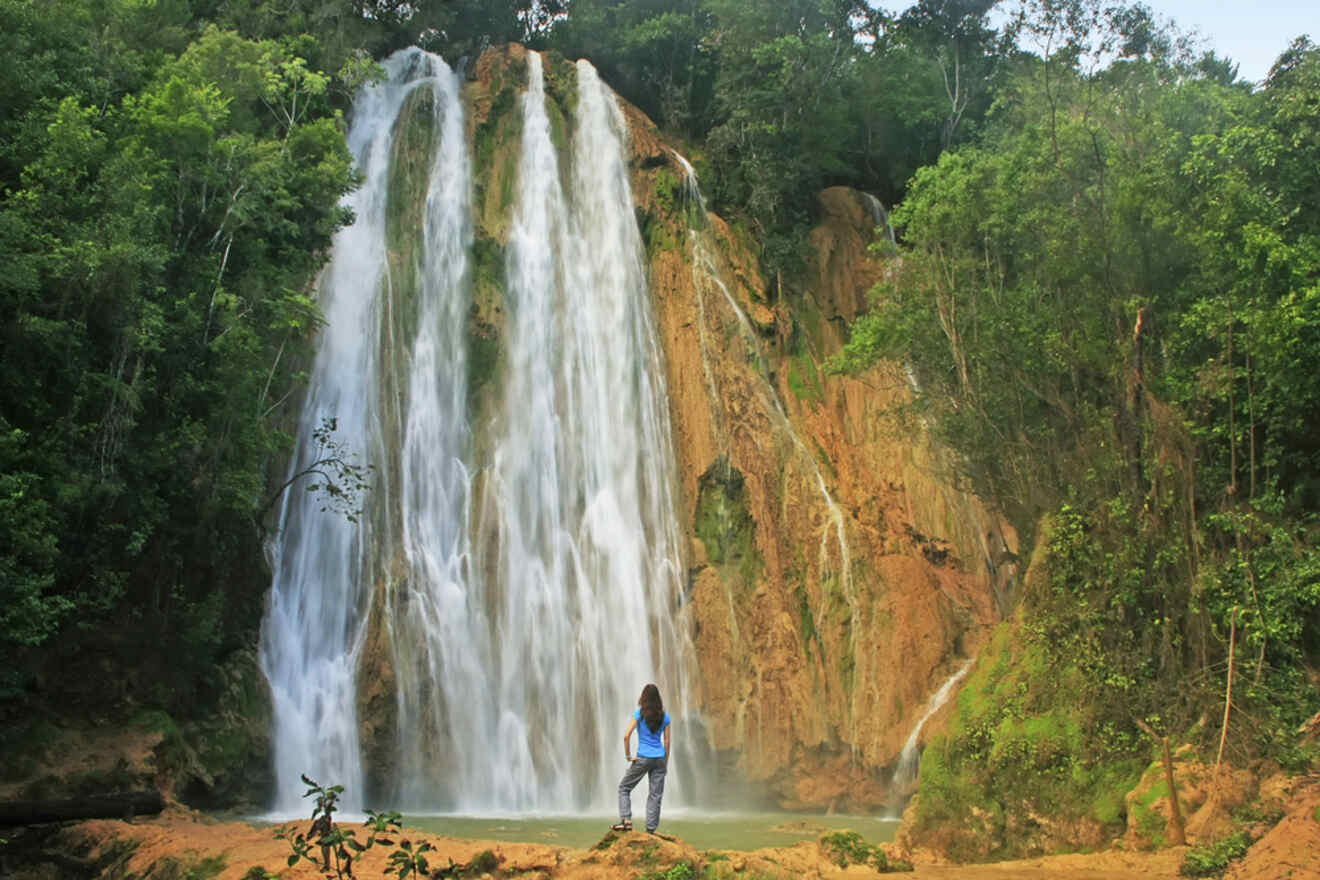 The majestic El Limon Waterfall in Samana with a single person standing in awe at its base.