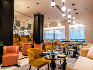 Vibrant boutique hotel interior with eclectic furniture, striking black accents, and pendant lighting