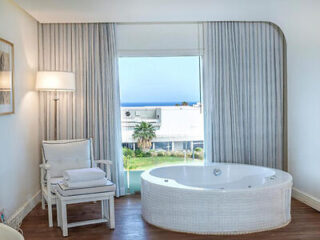 Luxurious room featuring a circular whirlpool bath with a sea view