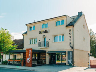 Exterior view of Sundial Boutique Hotel, showcasing its modern architecture with a welcoming entrance and outdoor seating