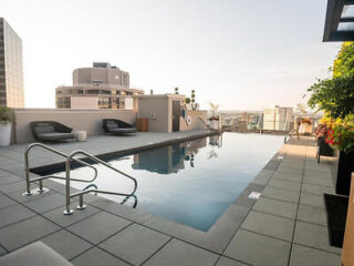 Rooftop pool area with lounge chairs and a serene view of the Philadelphia skyline