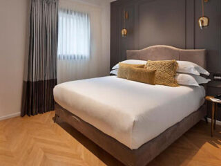 Contemporary hotel bedroom with a plush bed and textured pillows