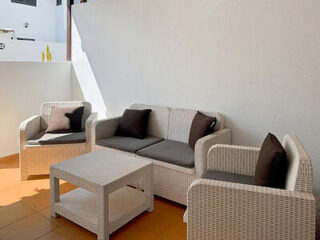 ontemporary outdoor seating area with wicker furniture and plush cushions