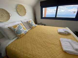 Intimate bedroom adorned with a mustard-colored quilt and decorative wall plates