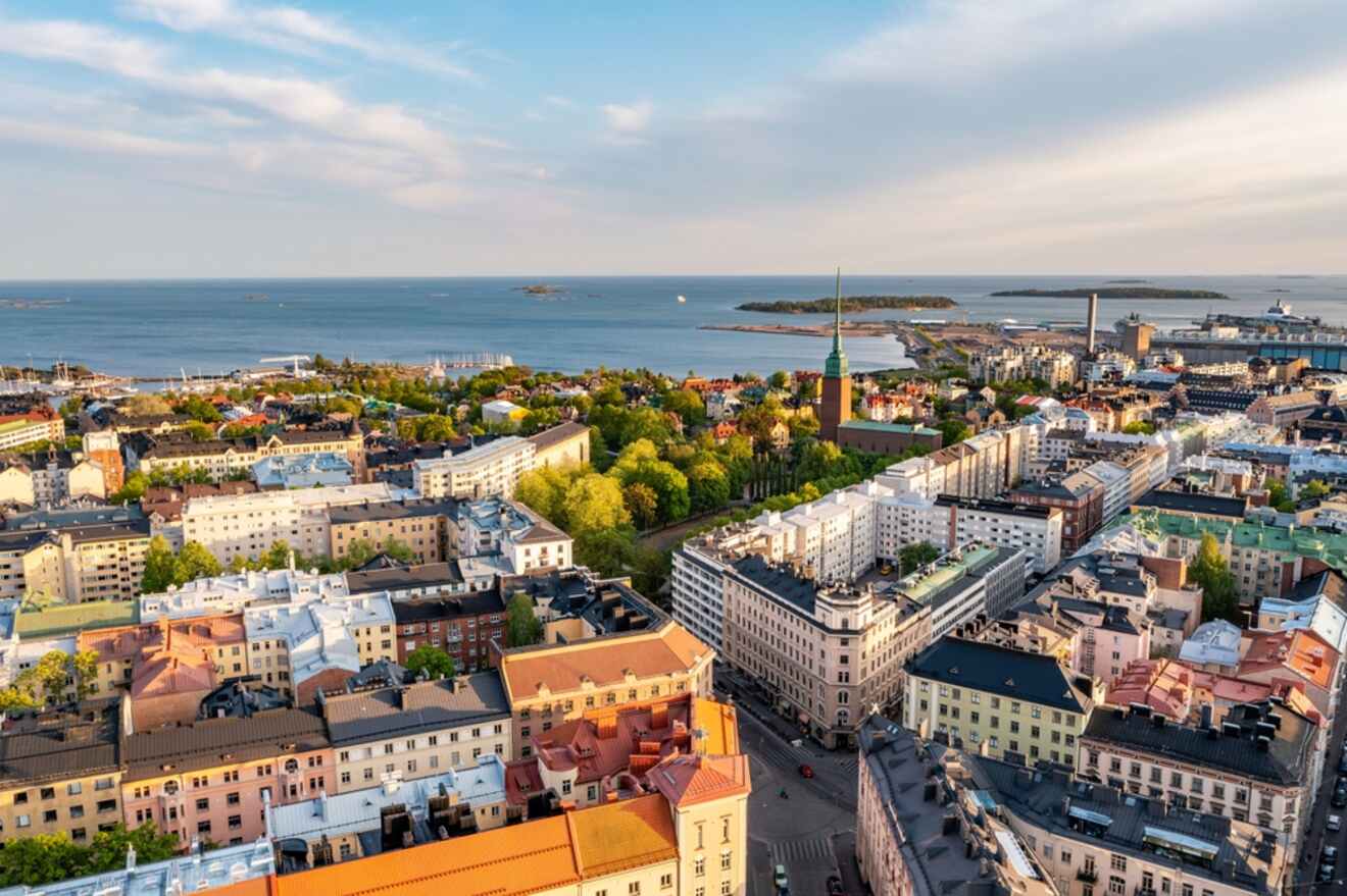 Aerial view of Helsinki at dusk, featuring a tapestry of buildings with the Baltic Sea in the backdrop, highlighting the city's blend of natural and urban landscapes