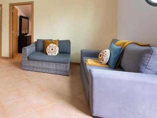 A cozy sitting area with modern wicker sofas complemented by grey cushions and yellow throw pillows