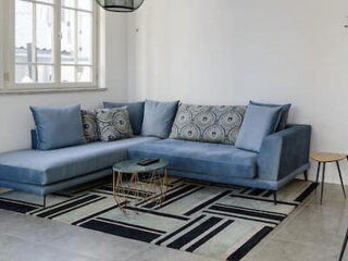 Chic living room with a large blue sectional sofa and patterned rug