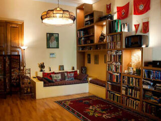 A homey living space filled with books, warm lighting, and a collection of cultural memorabilia
