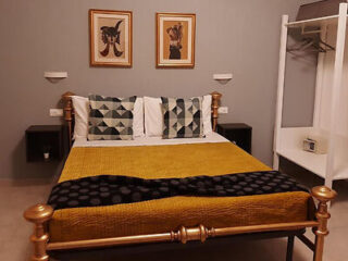 Luxurious bedroom with a golden brown bedspread on a grand brass-framed bed