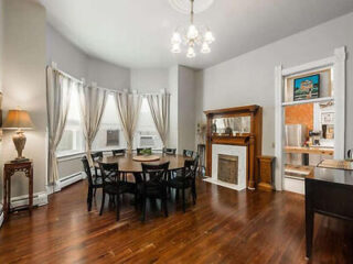 Elegant dining area in a home with hardwood floors, a large dining table set for six, and an open kitchen layout