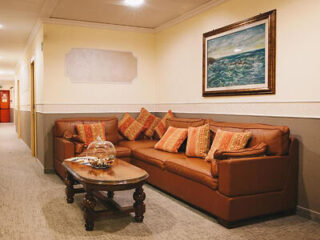 Elegant waiting area with a brown leather sofa set and a classic wooden coffee table