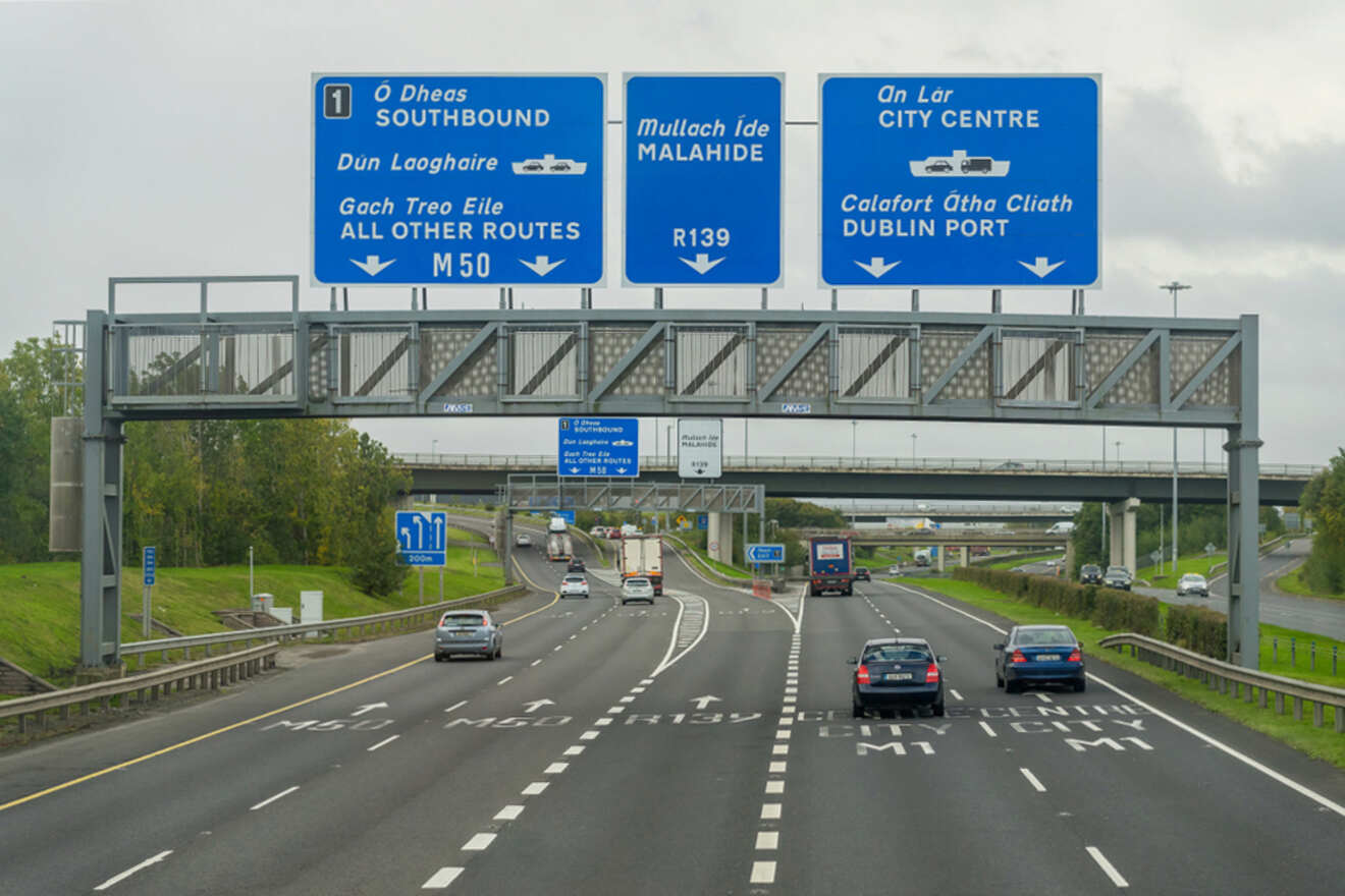 A highway leading towards Dublin with multiple blue direction signs overhead, guiding to destinations like Southbound, Malahide, and Dublin Port, depicting typical Irish motorway signage