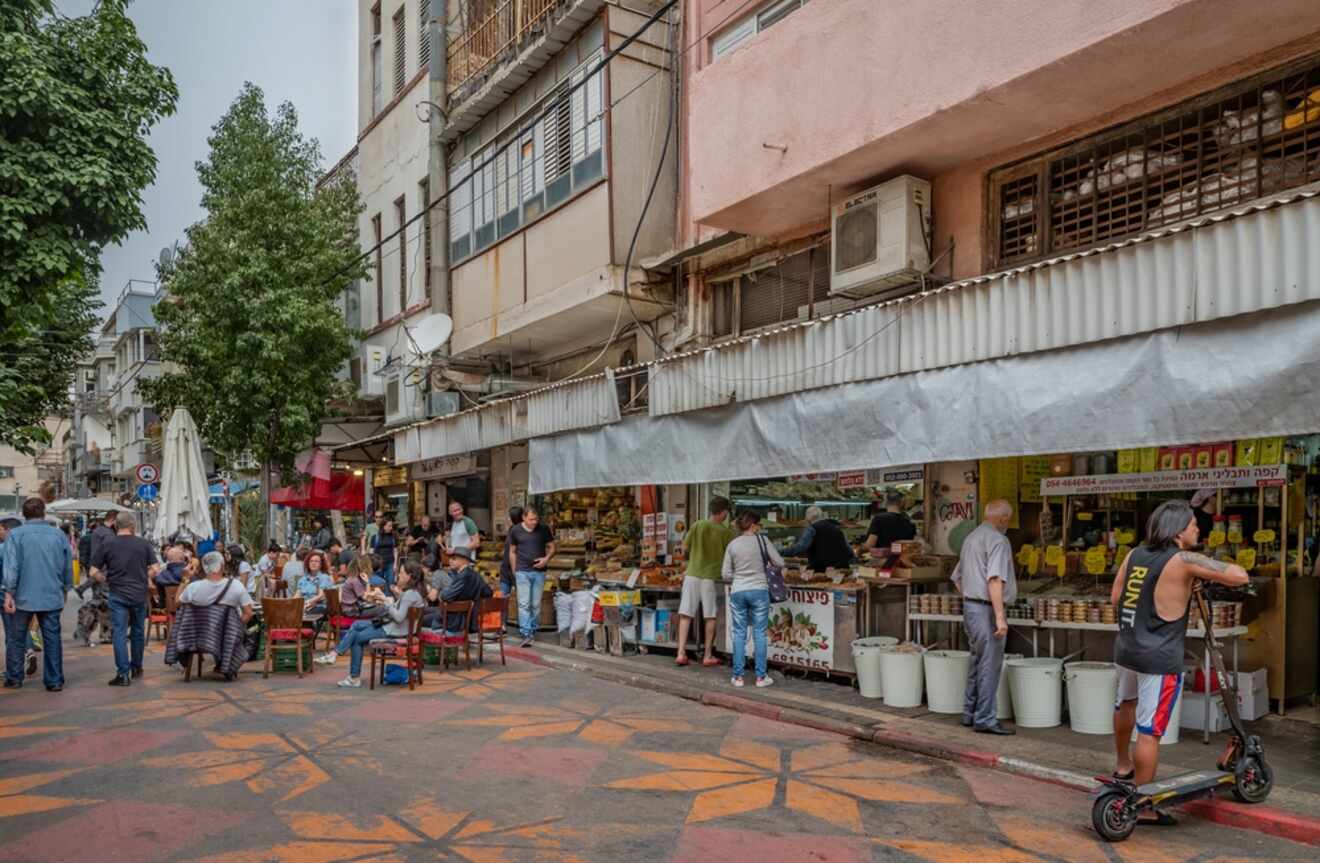 Eclectic Florentin neighborhood in Tel Aviv, showcasing street cafes and graffiti on a busy day