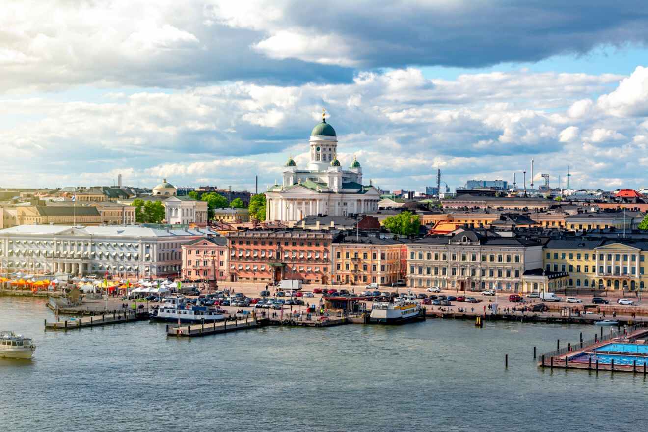 Scenic view of Helsinki's bustling South Harbor with boats docked along the Market Square and the iconic white Helsinki Cathedral rising in the background.