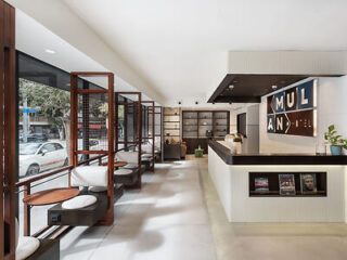 Sleek and modern hotel lobby with bookshelves, seating areas, and large sign