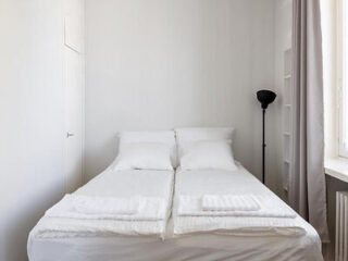 Simply furnished bedroom with a plain white bedspread on a double bed