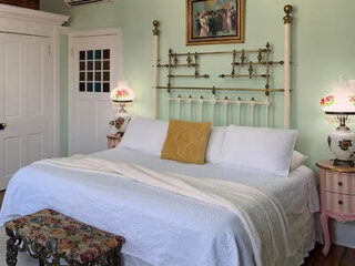 Traditional Victorian-style bedroom with antique brass bed frame and delicate floral accents