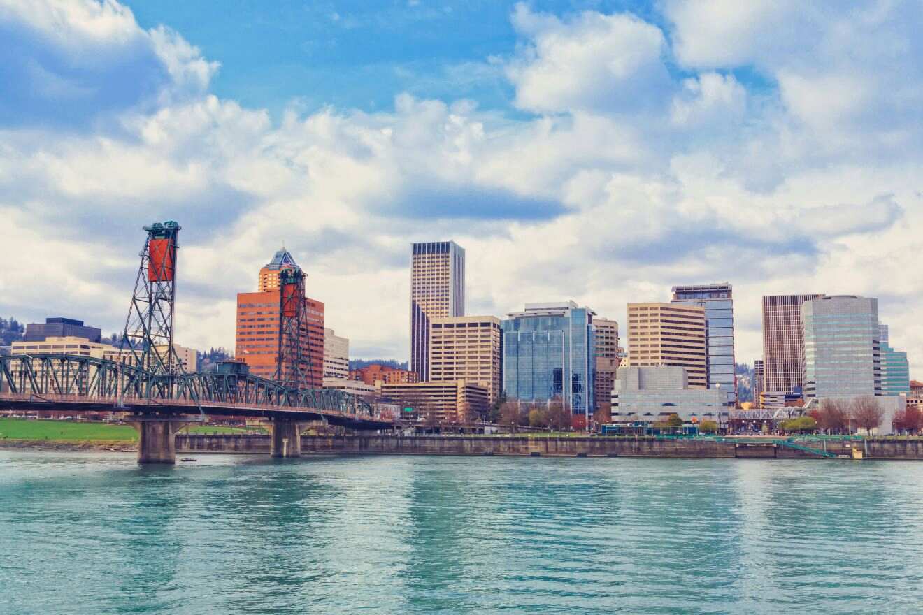 Portland's downtown skyline as seen from across the Willamette River with the Hawthorne Bridge in the foreground