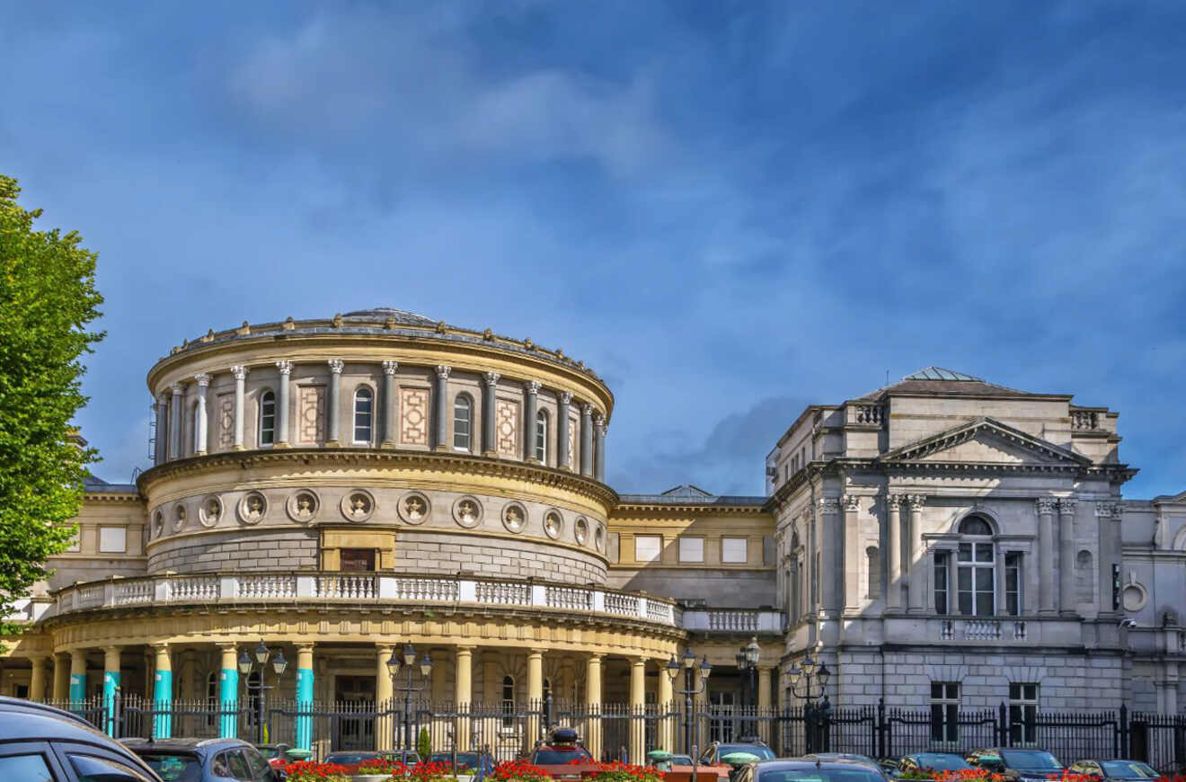 The neoclassical architecture of the National Library of Ireland in Dublin, with a rotunda and intricate façade details under a partly cloudy sky.