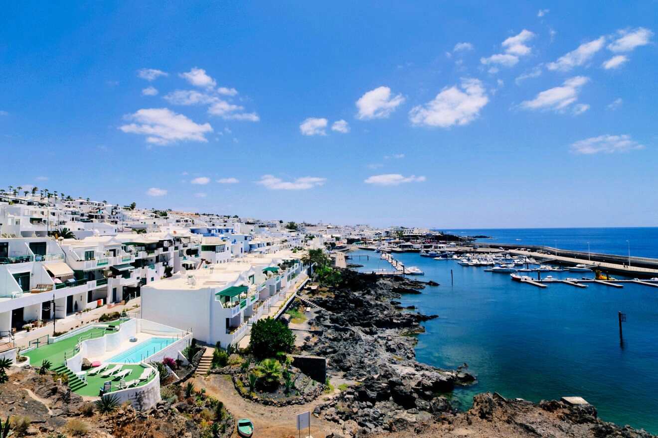 Scenic seascape from Puerto Calero, with traditional white Lanzarote buildings lining the coast and an expansive view of the ocean