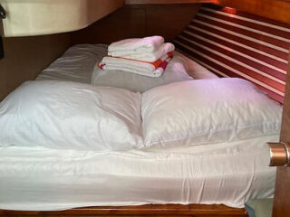 Compact yacht cabin with neatly made bed and plush pillows