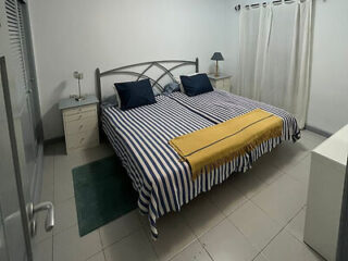 Bedroom featuring striped navy and white bedding with a mustard accent throw