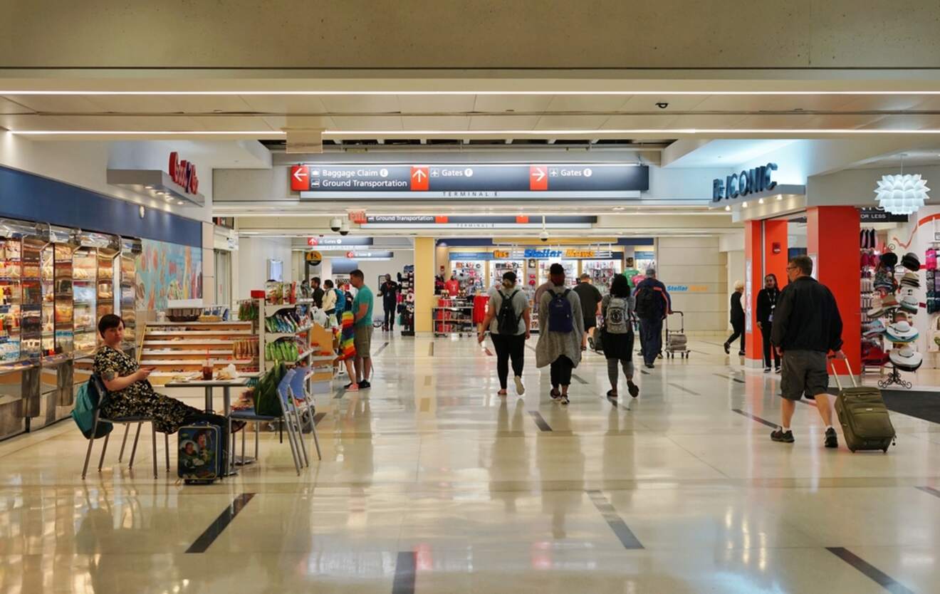 Interior of a busy airport terminal near Philadelphia, with travelers, shops, and directional signs, representing the hustle and bustle of travel
