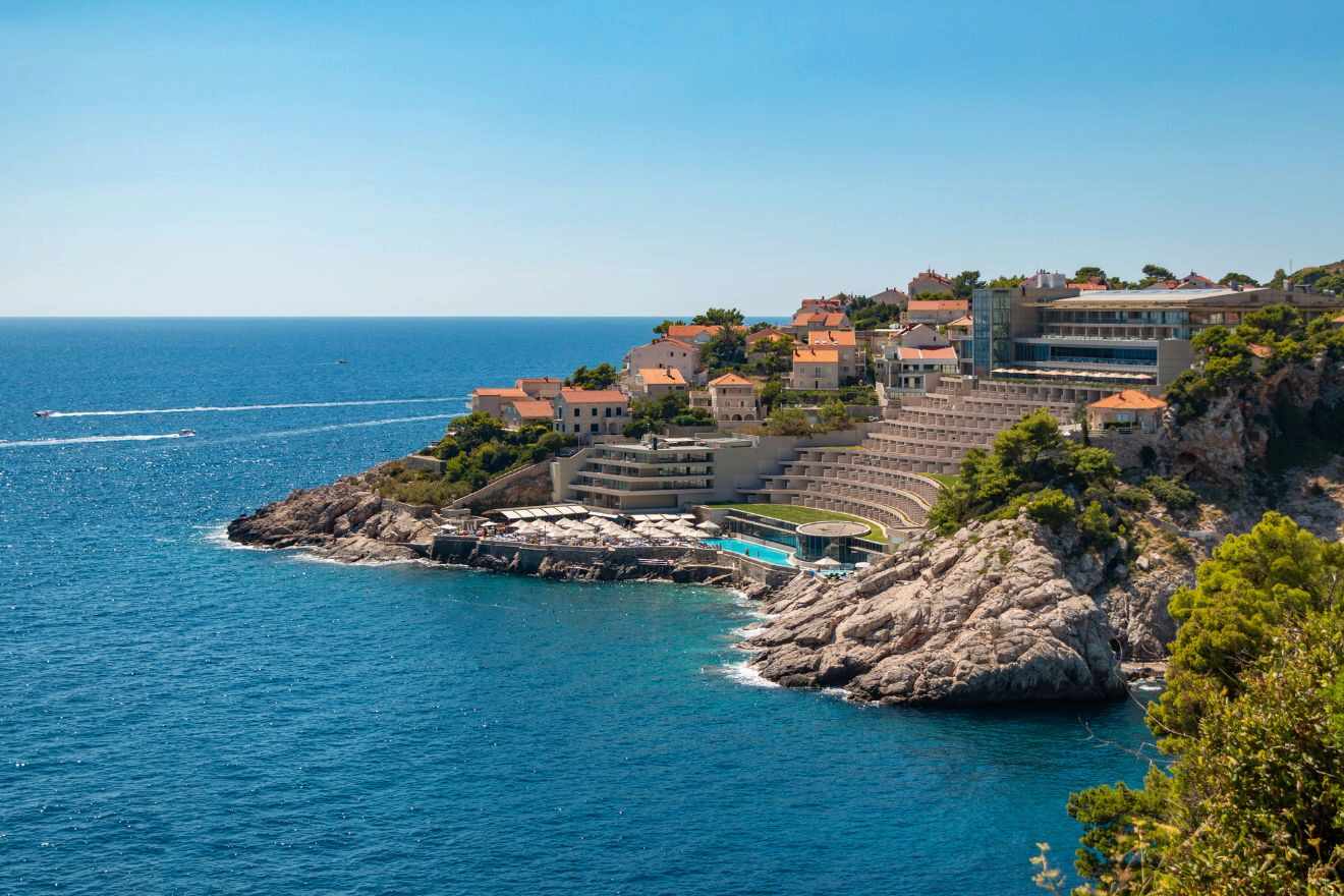 Luxury seaside hotel built into a cliff in Dubrovnik, overlooking the Adriatic Sea with tiered pools and terraces