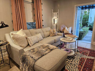 Elegant living area with a sectional sofa, chic decor, and access to a garden