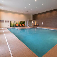 An indoor swimming pool with lounge chairs and a contemporary design.