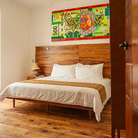 Hotel room featuring a wooden bed frame and headboard with a clean, minimalist design
